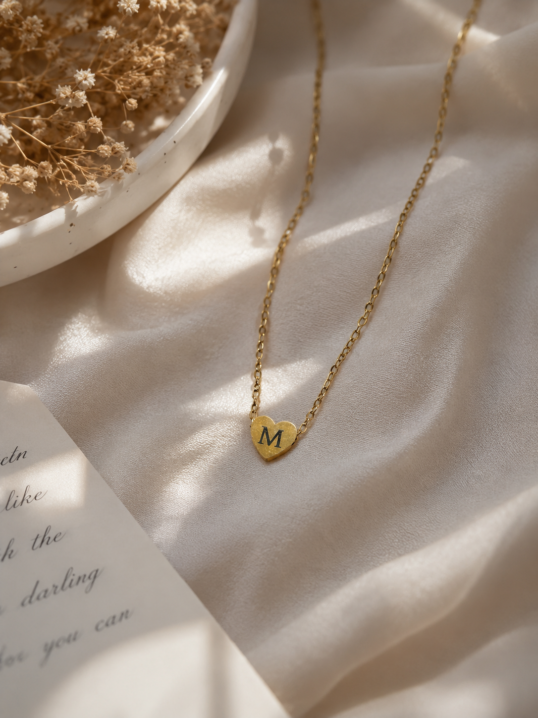 Personalized gold-tone stainless steel initial heart necklace worn by a woman